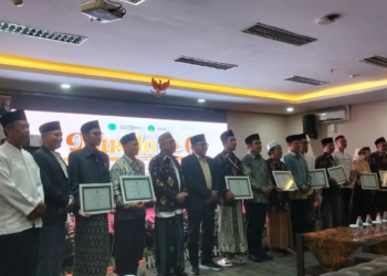 Bapak Dr. H. Abu Nasir, mewakili keluarga Bapak H. Djainuri (alm.), dan Ibu Ninis, mewakili Ibu Hj. Faruq (almh.), menerima penghargaan dari MUI Kota Pasuruan. foto istimewa