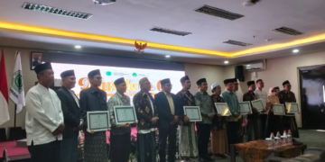 Bapak Dr. H. Abu Nasir, mewakili keluarga Bapak H. Djainuri (alm.), dan Ibu Ninis, mewakili Ibu Hj. Faruq (almh.), menerima penghargaan dari MUI Kota Pasuruan. foto istimewa