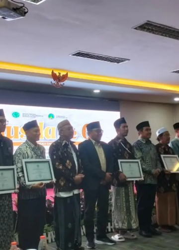 Bapak Dr. H. Abu Nasir, mewakili keluarga Bapak H. Djainuri (alm.), dan Ibu Ninis, mewakili Ibu Hj. Faruq (almh.), menerima penghargaan dari MUI Kota Pasuruan. foto istimewa
