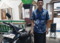 Pak Jayadi bergembira di samping motornya yang sudah normal/foto: Agus pasmu.id